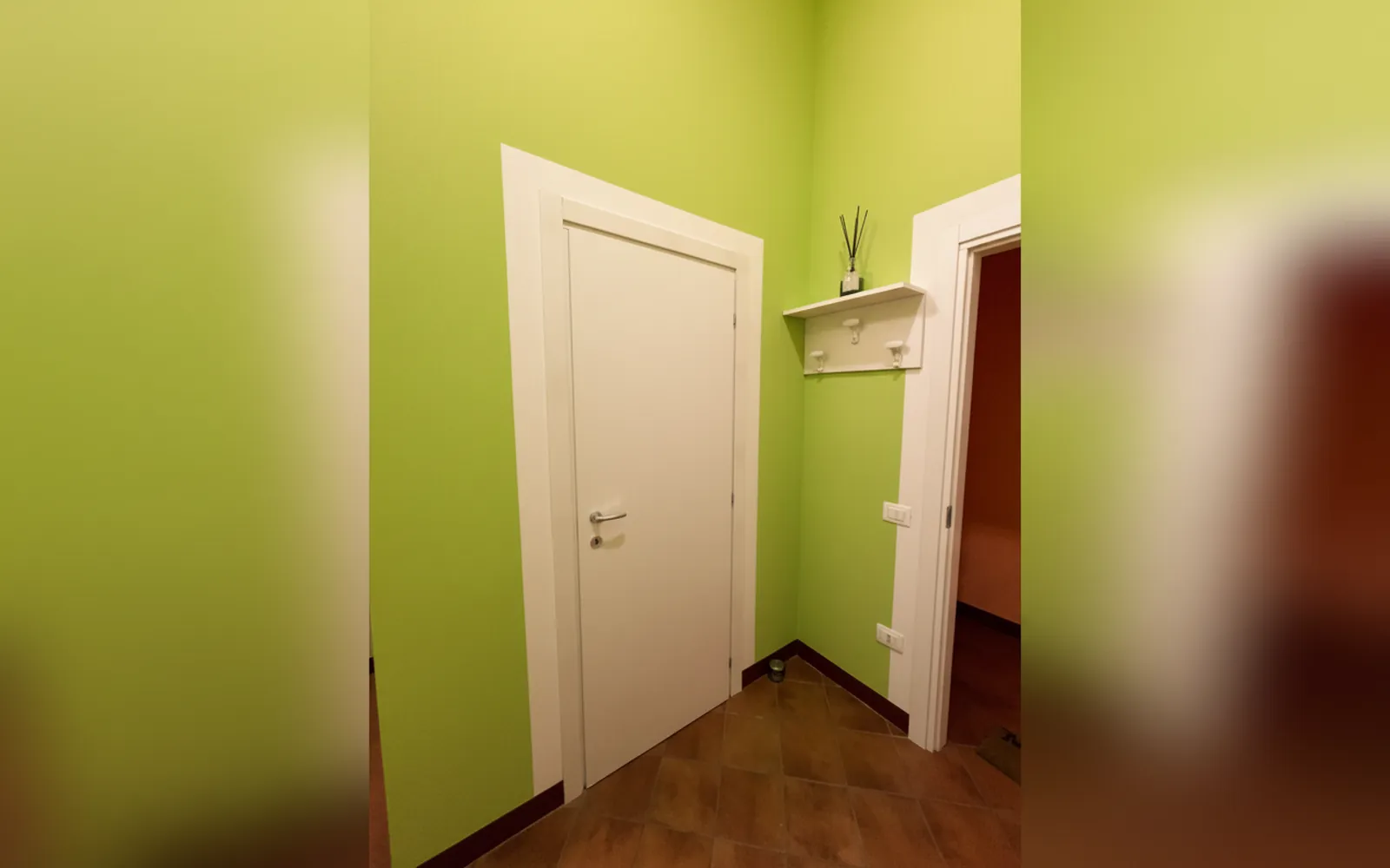 La porta d’ingresso della camera fra le pareti verdi