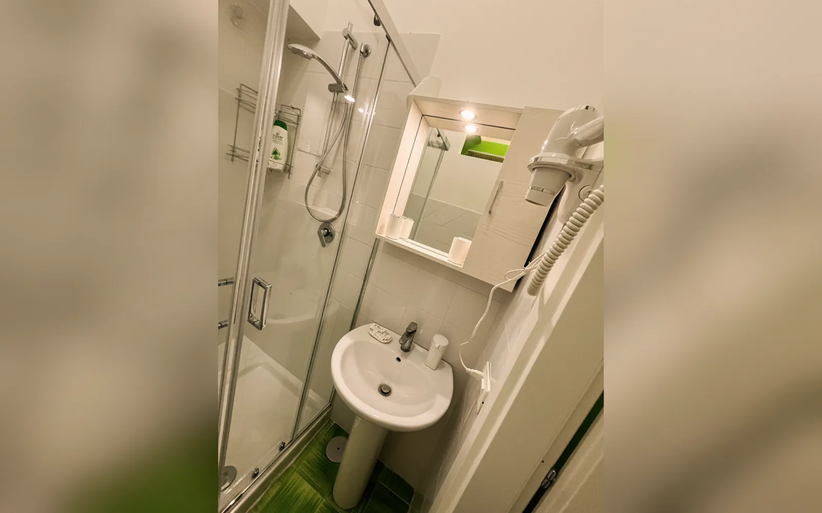 Il bagno privato con la doccia, il lavabo e lo specchio