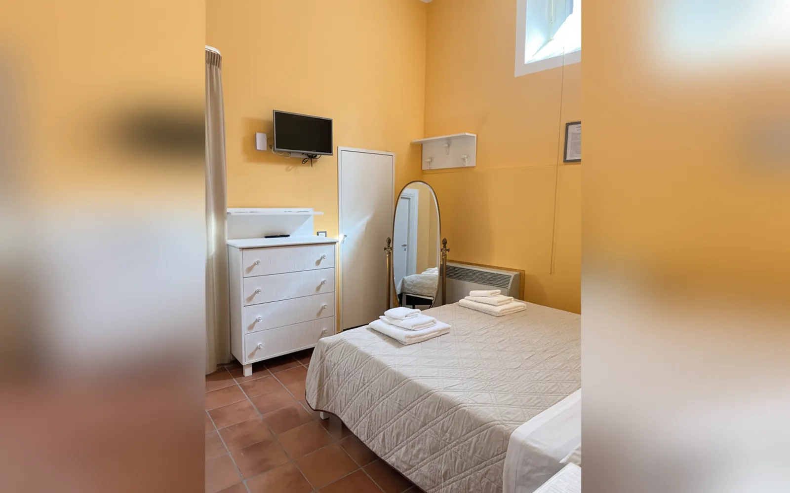 La cassettiera, la TV e lo specchio nella Camera Albicocca Pellecchiella